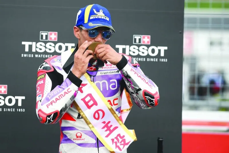 Wearing a sash that reads ‘Hero of the Day’, sprint race winner Prima Pramac Racing rider Jorge Martin of Spain, kisses his gold medal on the podium of Japanese Grand Prix at the Mobility Resort Motegi in Motegi, Tochigi prefecture, on Saturday. (AFP)