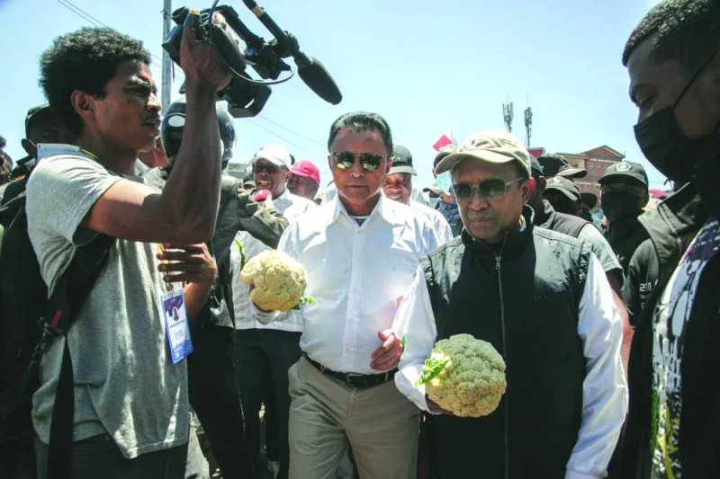 
Former Madagascar president and member of the opposition Marc Ravalomanana (second left) and former Madagascar president and opposition figure Hery Rajaonarimampianina (second right) hold a cauliflower, a vegetable that has become a symbol of police repression, as they join a march in Antananarivo, yesterday. 