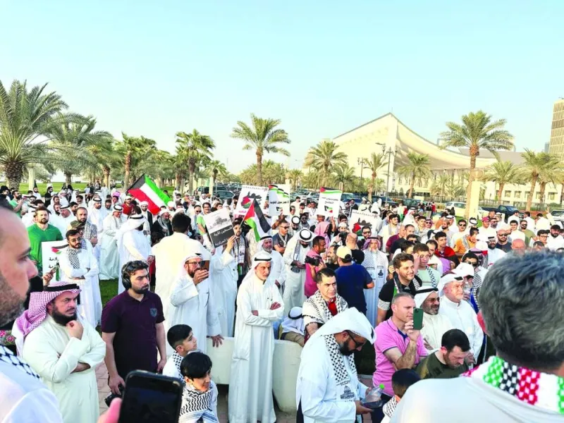
Protesters in support of Palestinians and Hamas’ “Al Aqsa Flood operation” stand close to Kuwait’s parliament building holding banners and Palestinian flags in Kuwait City, yesterday. 