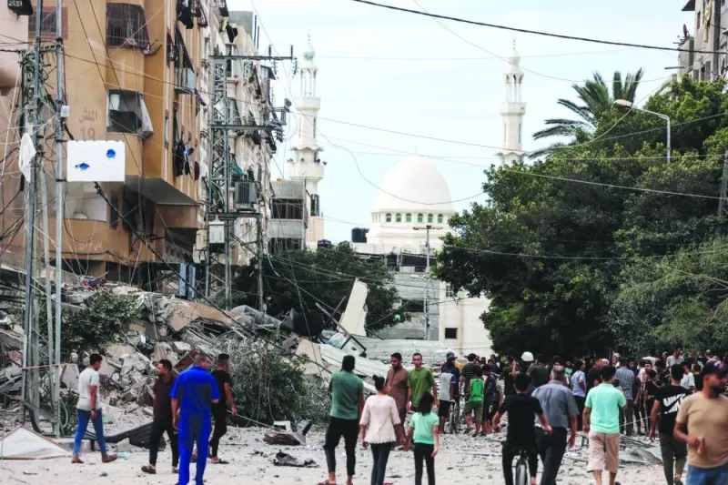 
People assess the destruction caused by Israeli air strikes in Gaza City, yesterday. 