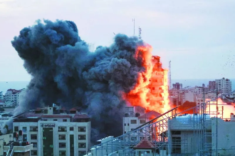 
Smoke and flames billow after Israeli forces struck a high-rise tower in Gaza City, yesterday. 