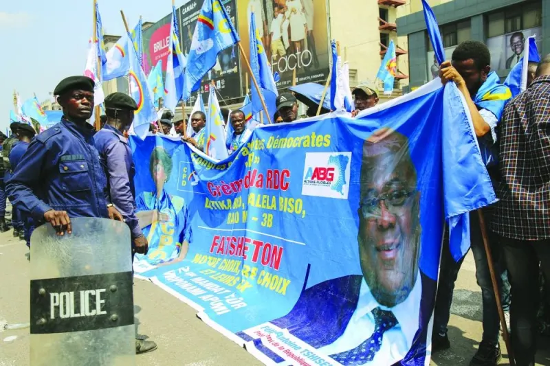 
Police officers stand in front of supporters of the various political parties that are members of the presidential coalition, as they accompany Democratic Republic of Congo President Felix Tshisekedi Tshilombo (not pictured) who filed his candidacy for the December presidential elections, in Kinshasa. 