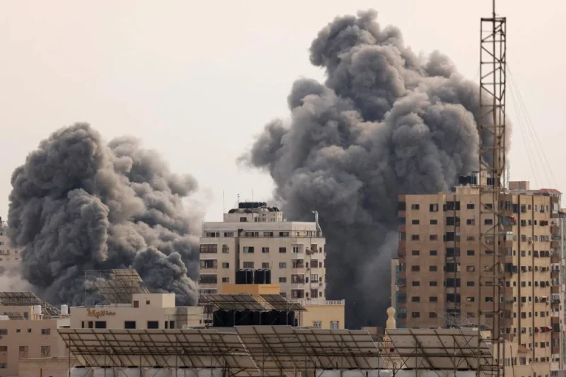 A black plume of smoke billows behind highrise buildings in the sky during an Israeli airstrike on Gaza City on Monday. Israel relentlessly pounded the Gaza Strip overnight and into October 9 as fighting with Hamas continued around the Gaza Strip, as the death toll from the war against the Palestinian militants surged above 1,100.  AFP
