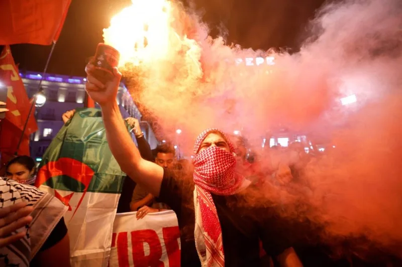 A protestor bearing keffieh holds a flare during a rally in support of Palestinians in Madrid Monday. AFP