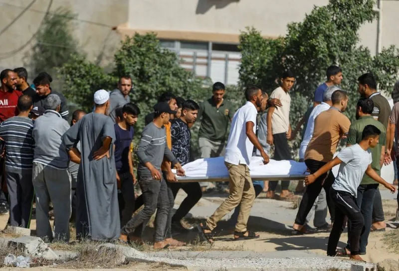 People carry the body of a Palestinian killed in Israeli strikes amid ongoing conflict between Israel and the Palestinian Islamist group Hamas, in Khan Younis in the southern Gaza Strip Friday. REUTERS