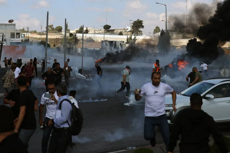 Palestinians scatter during clashes with Israeli soldiers at the north entarnce of the Palestinian city of Ramallah, near Beit El Jewish settlement, in the occupied West Bank on Friday. AFP