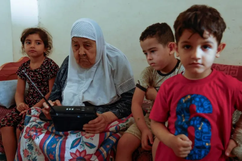 Palestinian woman Fawzeya Shaheen, 90, who lived through all Israeli-Palestinian wars dating back to 1948, sits with her grandchildren at her home, amid the ongoing Israeli-Palestinian conflict, in Khan Younis in the southern Gaza Strip Saturday. REUTERS