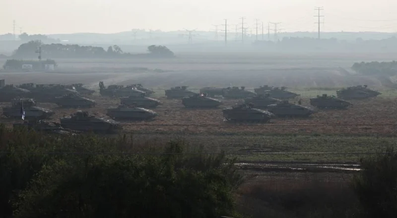 Israeli tanks and military vehicles take position near Israel&#039;s border with the Gaza Strip, in southern Israel, Saturday. REUTERS
