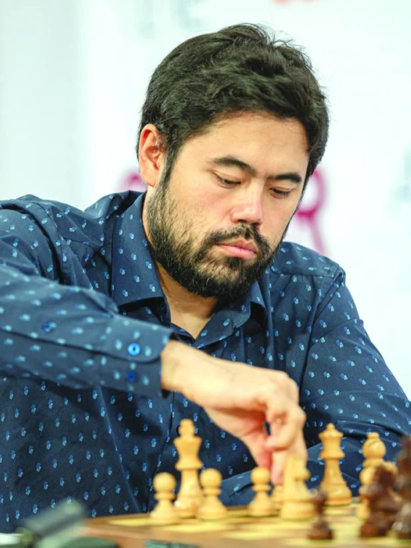 Indian Grandmaster M Pranesh (left) and Hikaru Nakamura of the US make their moves during their respective matches in round four of the Qatar Masters chess championship at Lusail Sports Arena on Saturday.
