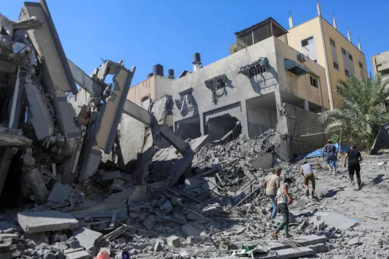 Palestinians run past the rubble following Israeli strikes in Gaza City Sunday. REUTERS