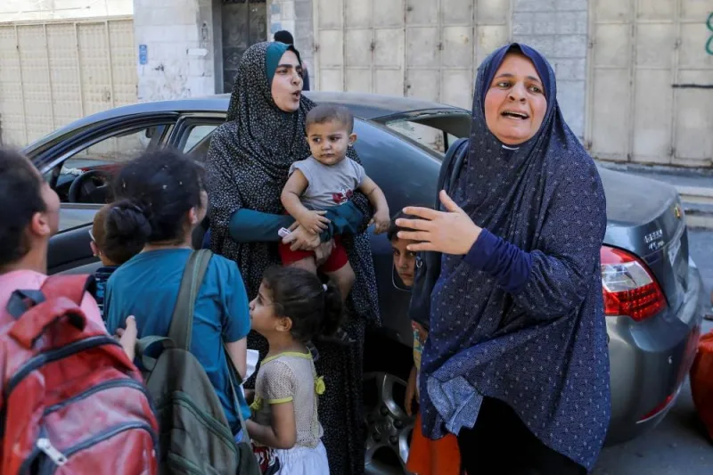 Palestinian women and children react following Israeli strikes in Gaza City Sunday. REUTERS