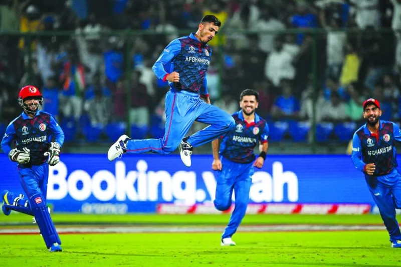 
Afghanistan’s Mujeeb Ur Rahman (second left) celebrates with teammates after taking the wicket of England’s Chris Woakes during the 2023 ICC Cricket World Cup match in New Delhi yesterday. (AFP) 