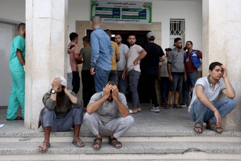 Palestinian men hold their heads as they sit on the steps of a hospital following an Israeli airstrike on buildings in Rafah, in the southern Gaza Strip on Tuesday. AFP