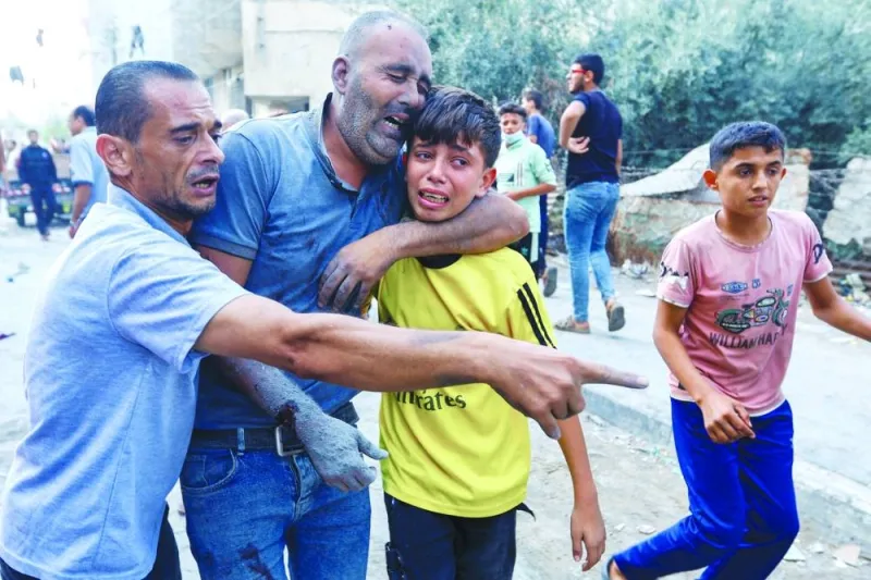 
A Palestinian man wounded in Israeli strikes on houses reacts with a boy in Rafah in the southern Gaza Strip, yesterday. 
