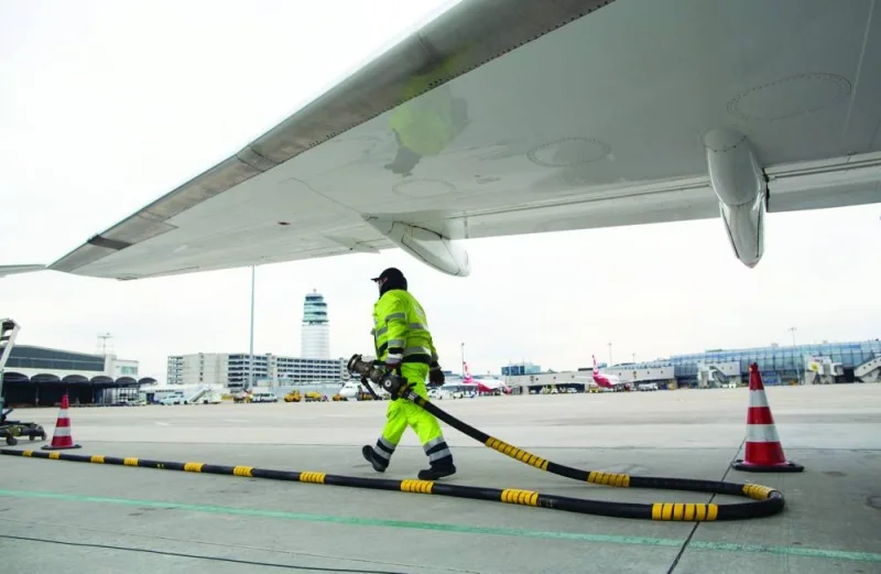 A ground crew worker carries a jet fuel pipe under a passenger aircraft on the tarmac at Vienna International Airport (file). The crisis in West Asia threatens to broaden into a regional conflict, which will have repercussions on oil supply and a spike in price including that of jet fuel.