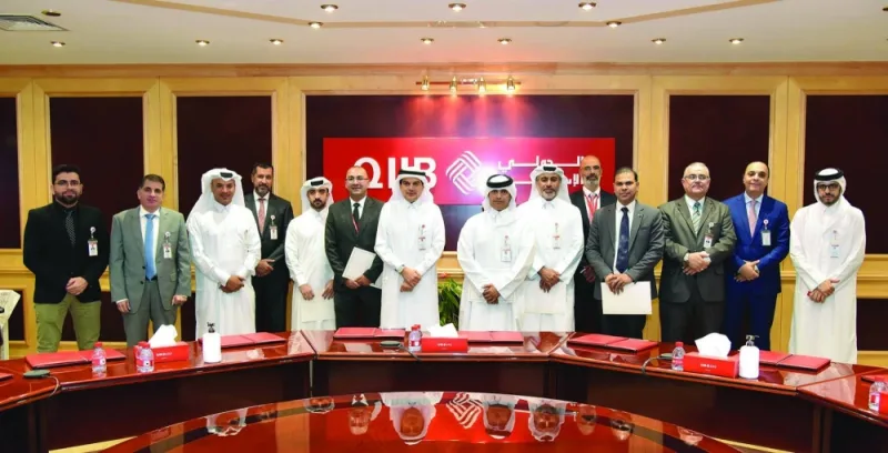 Honoured employees of QIIB with bank CEO Dr Abdulbasit Ahmad al-Shaibei and other senior executives.