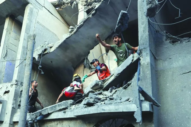 
Palestinian civil defence members and others carry a child killed in an Israeli bombardment from a building in Khan Yunis on the southern Gaza Strip. 