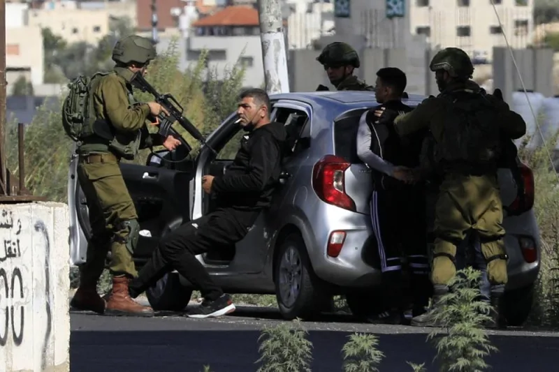Israeli soldiers detain Palestinians after stopping their car near Huwara checkpoint, the southern entrance to Nablus city, in the occupied West Bank Friday. AFP
