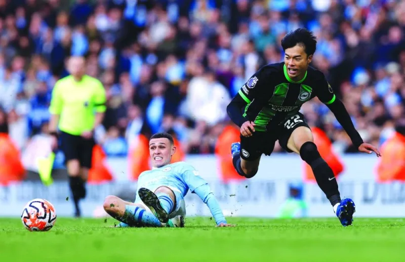 Manchester City’s Phil Foden (left) and Brighton’s Kaoru Mitoma vie for the ball during the Premier League match in Manchester on Saturday.  (Reuters)