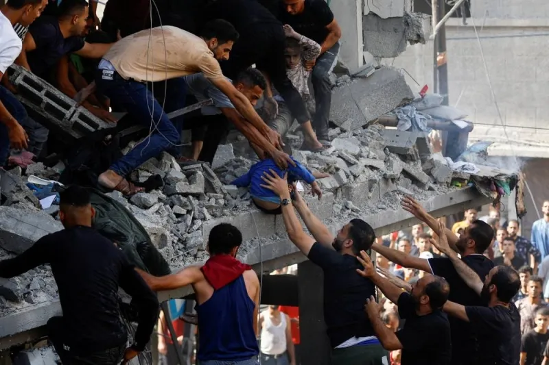 Palestinians carry a child casualty at the site of an Israeli strike on a house, in Khan Younis, in the southern Gaza Strip, on Tuesday. REUTERS
