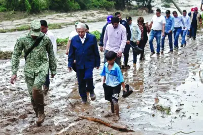 
Mexican President Andres Manuel Lopez Obrador (third from left) and members of his cabinet walk on the mud as they visit the El Kilometro 42 community, near Acapulco, after the passage of Hurricane Otis. 
