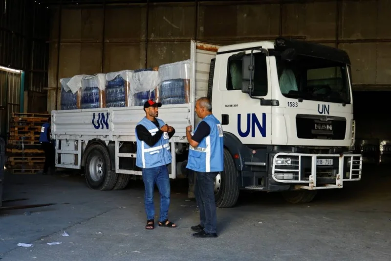 Workers stand by a United Nations vehicle, while sorting aid to be distributed to Palestinians at a United Nations-run facility, in Khan Younis in the southern Gaza Strip, Thursday. REUTERS