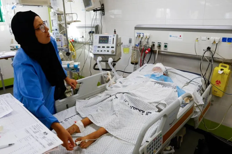 A medical worker assists a Palestinian boy, who was wounded in Israeli strikes, at the Intensive Care Unit (ICU) of Nasser hospital, as doctors say they are only able to accept critical cases that are in need of surgery, while the unit is filled up with victims of the ongoing conflict with Israel, in Khan Younis, in the southern Gaza Strip, Thursday. REUTERS