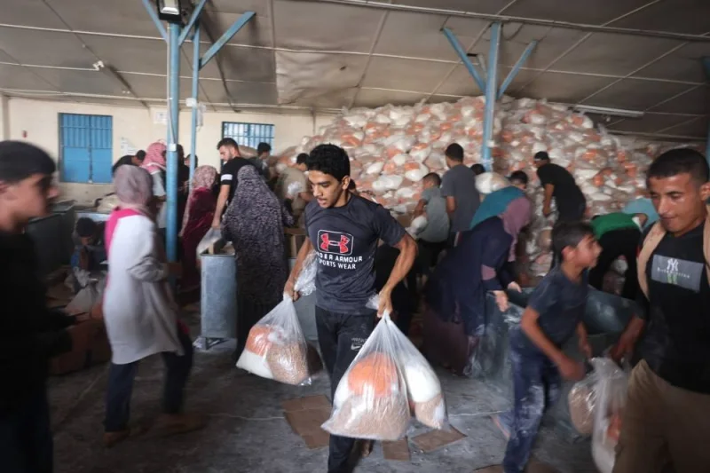 Palestinians storm a UN-run aid supply center, that distributes food to displaced families in Deir al-Balah on Saturday. AFP