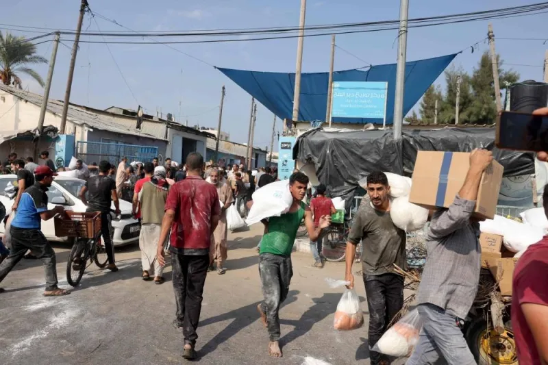 Palestinians storm a UN-run aid supply center, that distributes food to displaced families in Deir al-Balah on Saturday. AFP