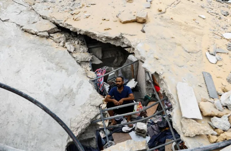 A Palestinian man sits amidst the rubble at the site of Israeli strikes on houses in Khan Younis in the southern Gaza Strip, on Sunday. REUTERS