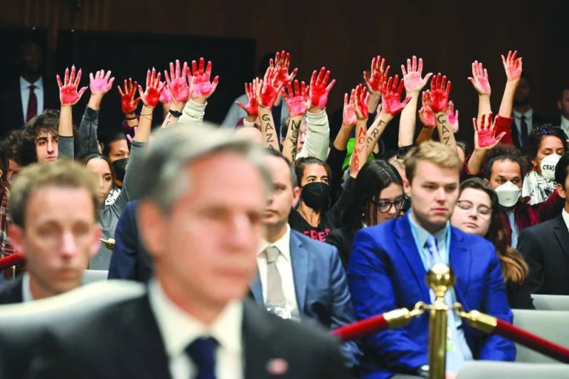 Protesters raise their painted hands as US Secretary of State Antony Blinken and Defense Secretary Lloyd Austin testify during a Senate Appropriations Committee hearing on Capitol Hill in Washington, DC, on Tuesday. (AFP)