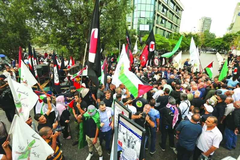 People lift flags during a protest near the French embassy in Beirut, on Tuesday, in support of Palestinians in Gaza.