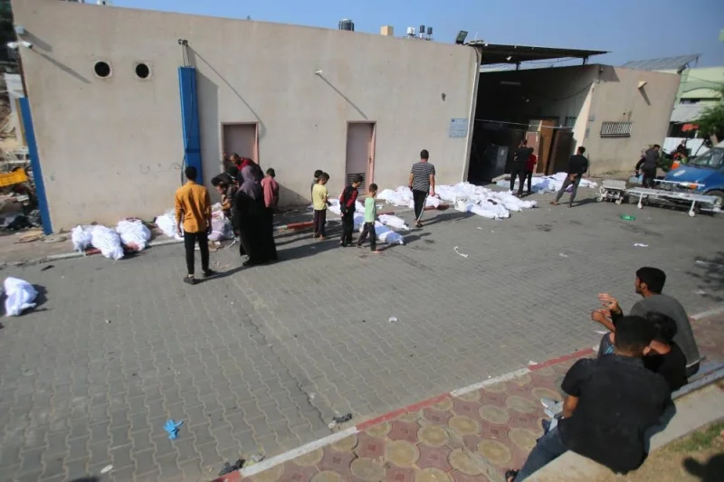Palestinians walk past the bodies of victims lying down outside a hospital morgue in Gaza City a day after an Israeli strike in the Jabalia camp for Palestinian refugees, on Wednesday. AFP
