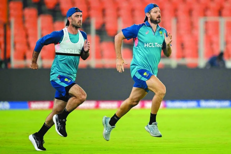Australia’s Glenn Maxwell (left) and Michael Neser attend a practice session on the eve of the 2023 ICC World Cup match against England in Ahmedabad. Right: England’s Ben Stokes (centre) is seen with teammates during a practice session in Ahmedabad. (AFP)