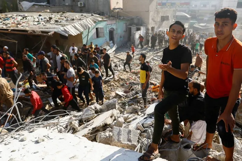 Palestinians gather at the site of Israeli strikes on a residential building, amid the ongoing conflict between Israel and Palestinian Islamist group Hamas, in Khan Younis in the southern Gaza Strip, on Saturday. REUTERS