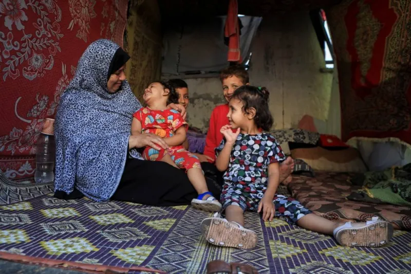A displaced Palestinian woman, who fled her house due to Israeli strikes, sits with her grandchildren in a makeshift shelter at Shifa hospital, in Gaza City on Sunday. REUTERS
