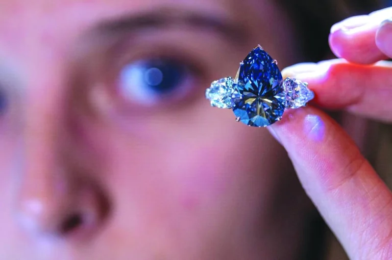 
Christie’s auction house intern Carola Chiadini holds the “Bleu Royal” diamond, weighing 17.61 carats, which is the largest to appear for sale in auction history in Geneva. (Reuters) 
