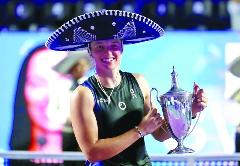 
Poland’s Iga Swiatek celebrates with the WTA Finals trophy after winning her final match against Jessica Pegula of the US in Cancun, Mexico, on Monday night. (Reuters) 
