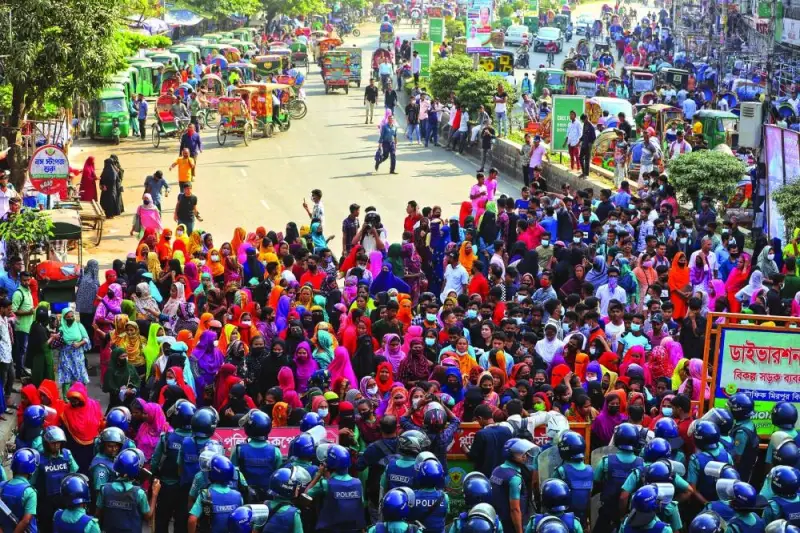 
Garment workers block a key intersection as they protest in Dhaka yesterday, demanding a near-tripling of the minimum wage to 23,000 taka ($208). 