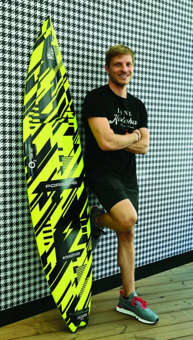 
German surfer Sebastian Steudtner poses with his new board at the booth of German car producer Porsche of the IAA Automobile show in Munich in September. (AFP) 