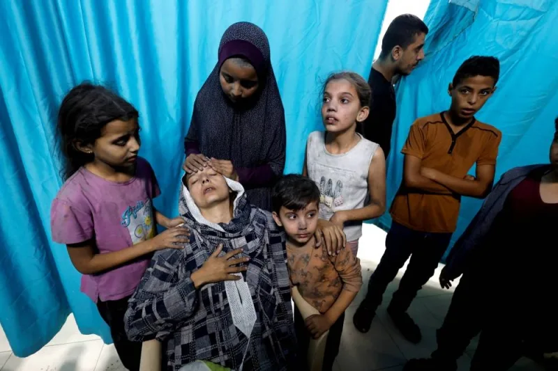 A Palestinian woman and children react after Israeli strikes, at a hospital in Khan Younis in the southern Gaza Strip, on Monday. REUTERS