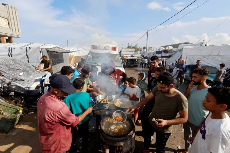 Palestinians cook food at a temporary shelter, in Khan Younis in the southern Gaza Strip, on Tuesday. REUTERS