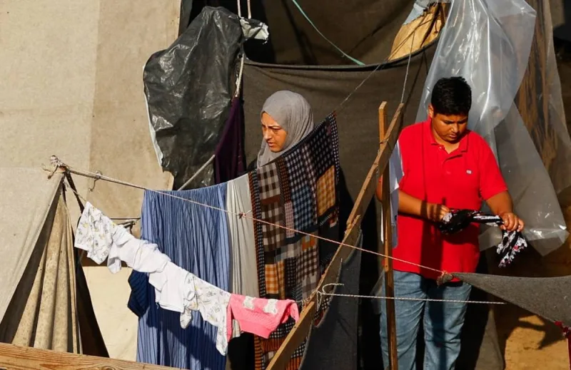People hang out the laundry at a tent camp sheltering displaced Palestinians following a rainfall, in Khan Younis in the southern Gaza Strip, on Tuesday. REUTERS
