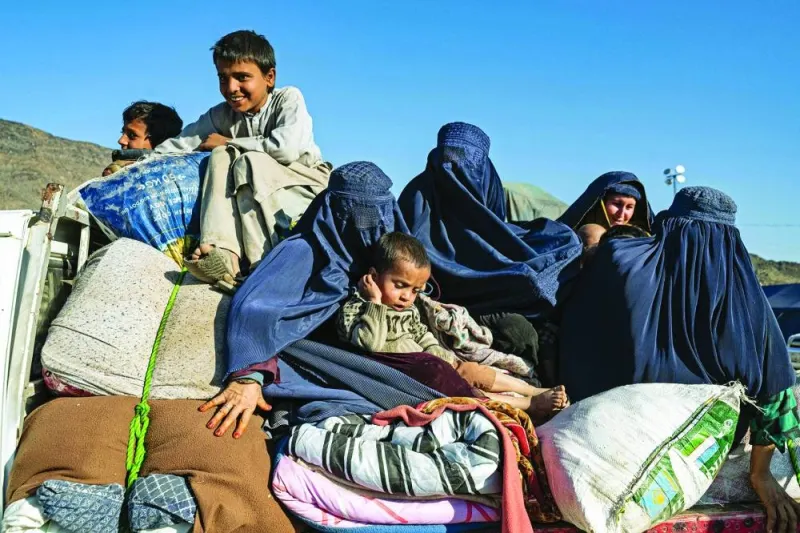 In this photograph taken on November 12, an Afghan mother of three children holds an infant while travelling on a truck to Jalalabad from a makeshift camp near the Afghanistan-Pakistan Torkham border in Afghanistan's Nangarhar province, days after their deportation from Pakistan.