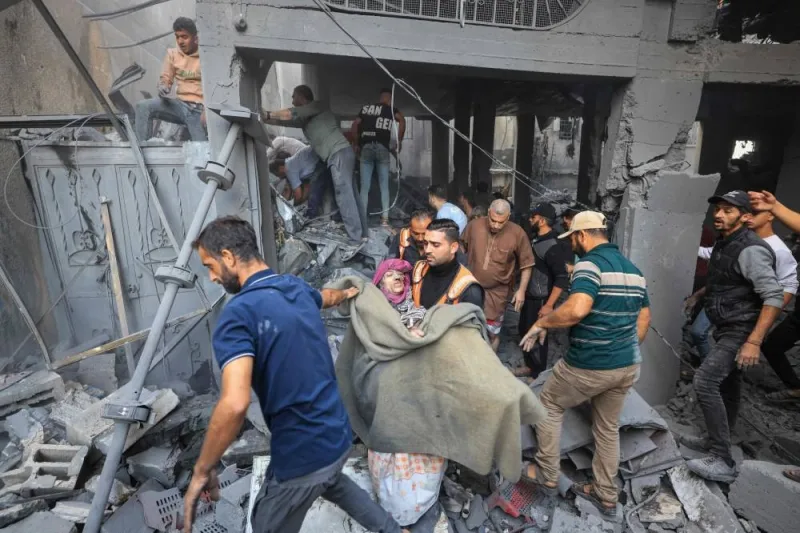 Palestinians carry an injured person as rescuers search the rubble of a building for survivors following Israeli bombardment in Khan Yunis in the southern Gaza Strip, on Saturday. AFP
