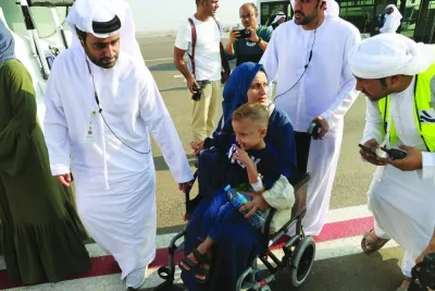 Emiratis speak with a Palestinian mother carrying her child on their arrival in Abu Dhabi, yesterday, after being evacuated from Gaza as part of a humanitarian mission organised by the United Arab Emirates.