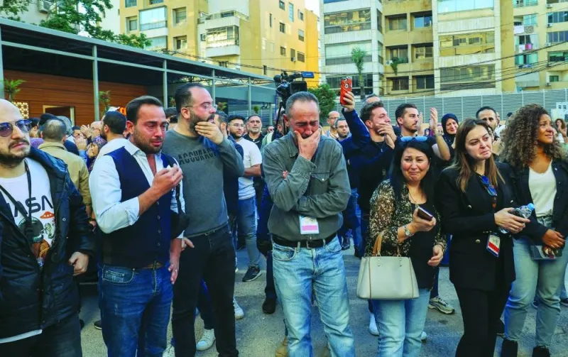 Colleagues of two journalists of Lebanon-based Al Mayadeen TV channel, killed in an Israeli strike in Tair Harfa earlier, mourn as 
ambulances carrying their bodies arrive for a last visit outside the channel’s building in Beirut, yesterday.