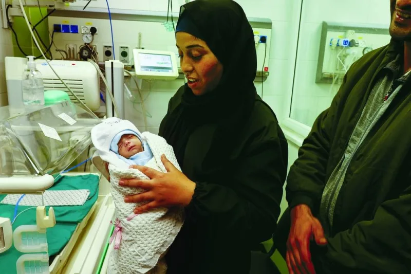 
A Palestinian mother holds her newborn Anas Sbeta, who was placed in an incubator after being evacuated from Al-Shifa Hospital in Gaza City due to the ongoing conflict, as he is discharged from a hospital in Rafah, southern Gaza Strip, yesterday. 