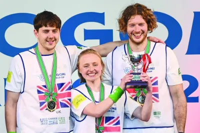 Britons Jonathan Winship (left), Sarah Parry (centre) and Alexander Winship pose with the trophy after winning the 'SpoGOMI World Cup 2023' final in Tokyo yesterday. (AFP)