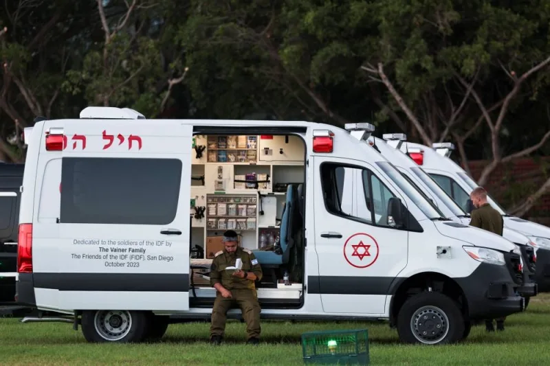 A man reads a book as he sits on an ambulance before the arrival of a vehicle carrying hostages released as part of a deal between Israel and Hamas at Schneider Children&#039;s Medical Center in Petah Tikva, Israel, Friday. REUTERS